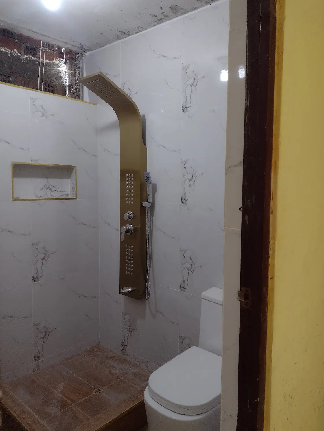 Baño enchapado en porcelanato con ducha en Lima
